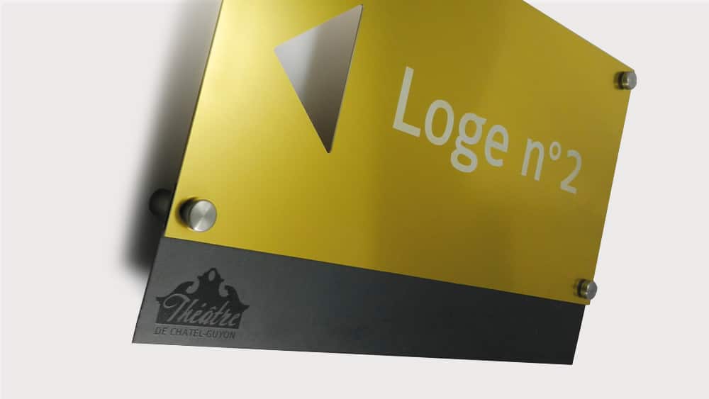Ensemble signalétique de théâtre réalisée en gravure laser sur aluminium anodisé or et contre-plaque inox avec logo imprimé 