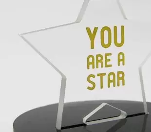 Trophée publicitaire en forme d’étoile réalisé en plexiglas transparent avec marquage doré..