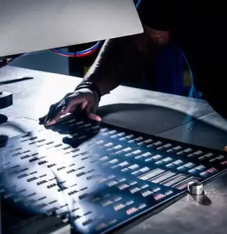 Technicien réalisant un embossage en relief sur plaque métallique chez Marquage Moderne